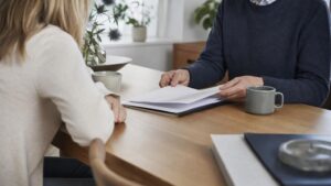 To personer gennemgår dokumenter om arveafgift testamente ved et bord.